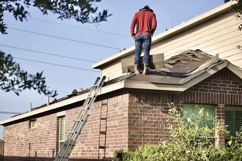 Professional roofer working on a residential roof in Ernest